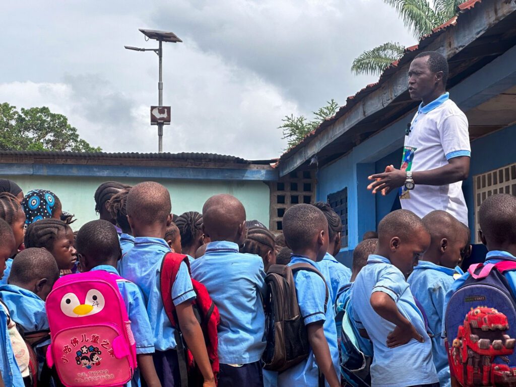 Teacher speaking to school children outdoors