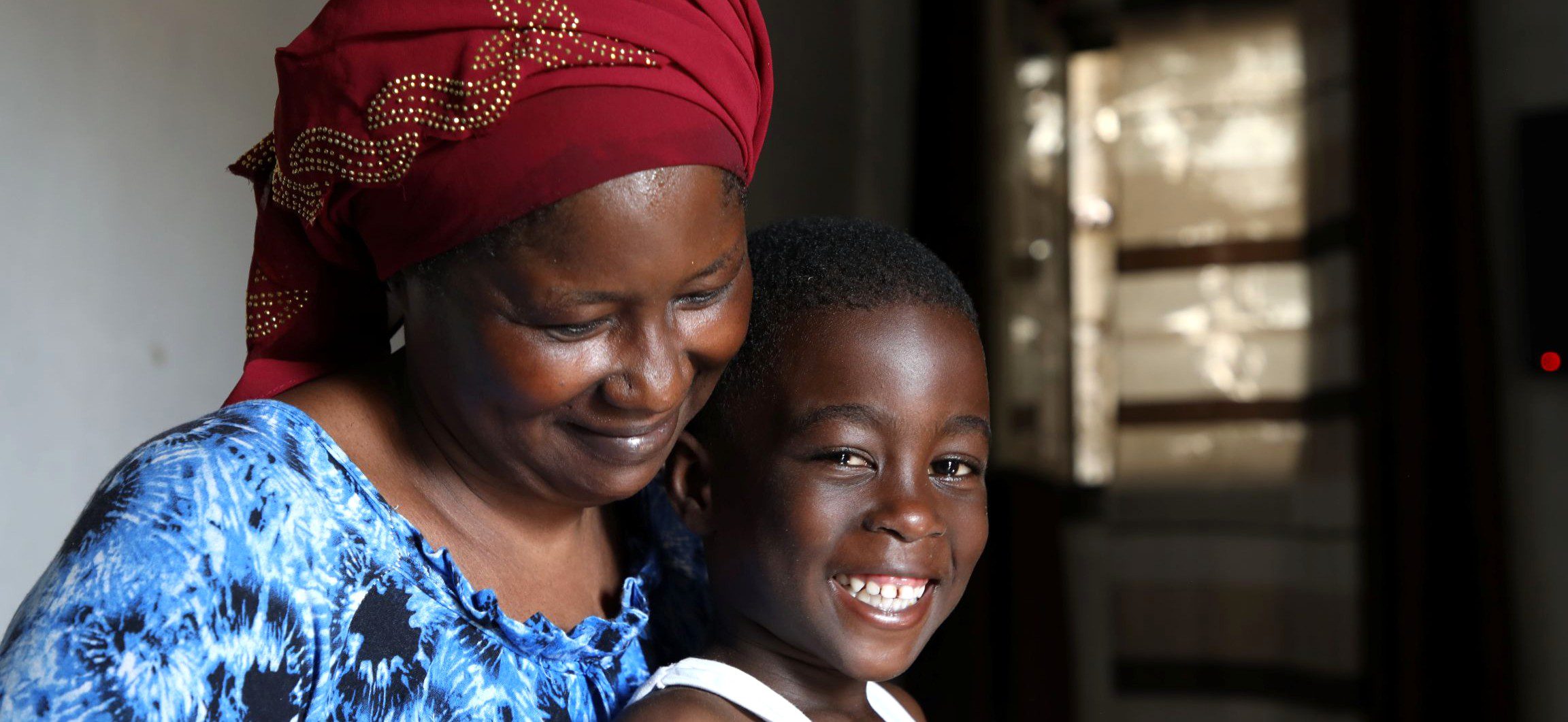 African mother hugging smiling young boy