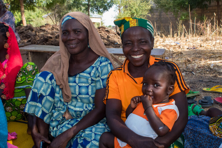 African women smiling with child outdoors