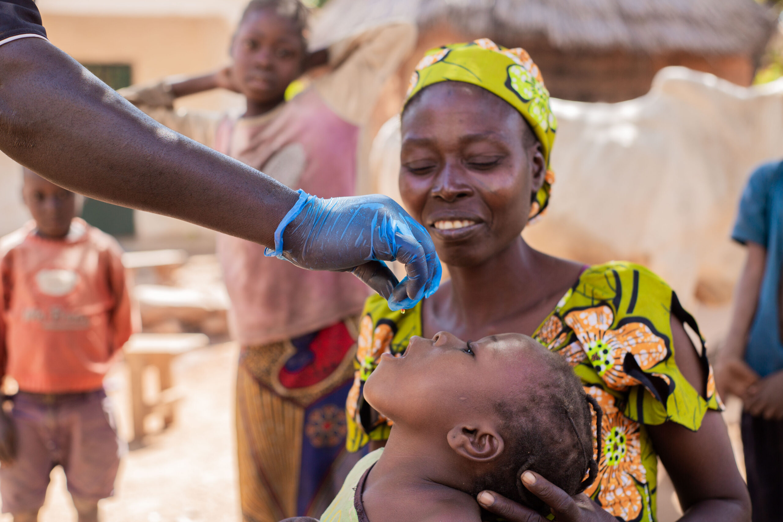 Child receiving oral vaccine from health worker