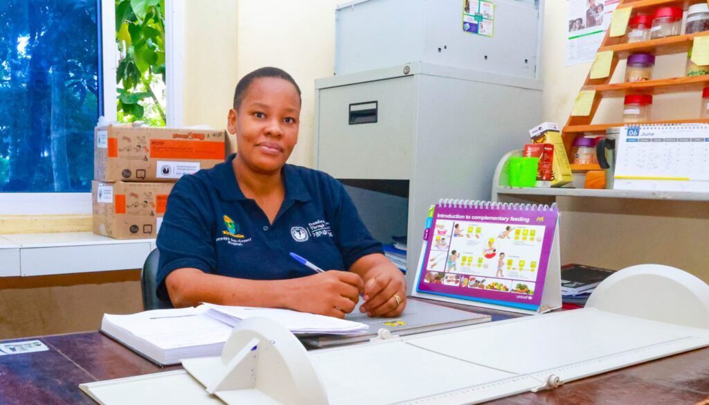 Devota Leandry with child growth chart and nutrition guide