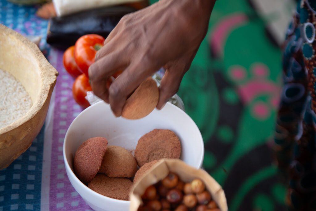 Hand picking kola nuts from bowl