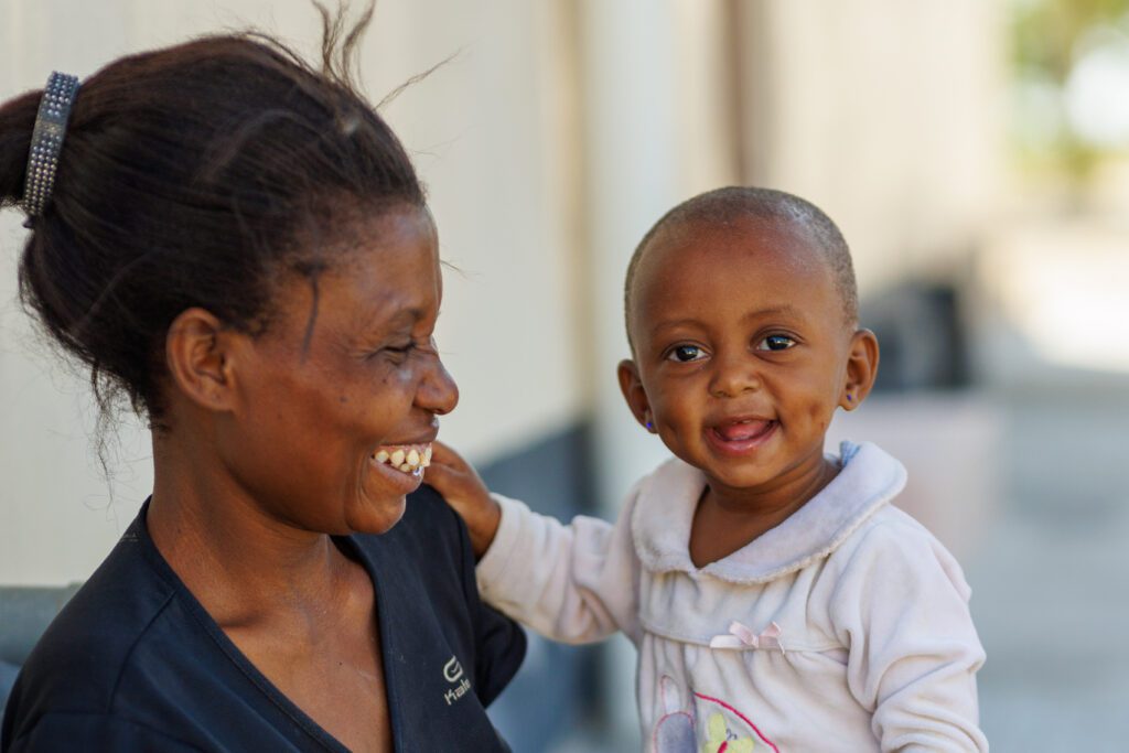 Mother smiling holding happy baby girl