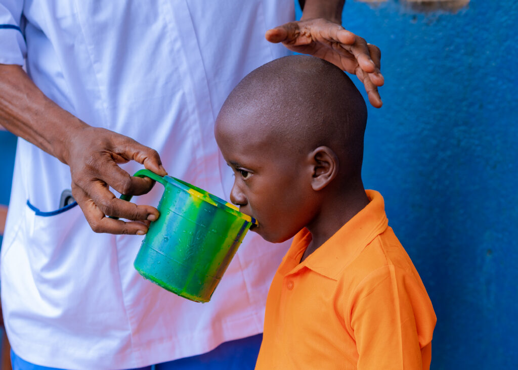 Boy drinking water from green cup