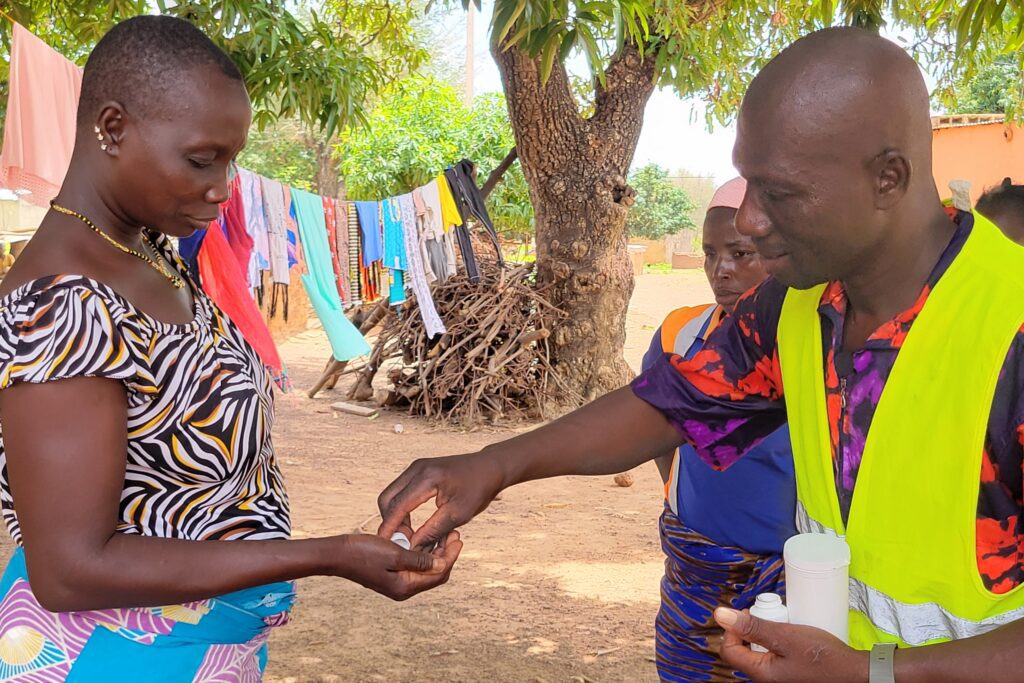 Man giving pills to woman outside