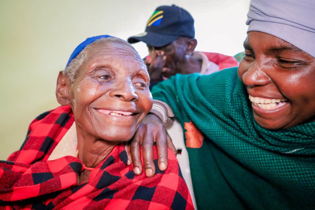 Elderly woman smiling with caregiver embracing