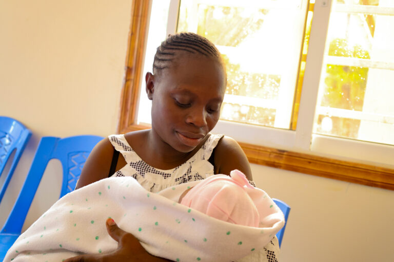 Mother holding newborn baby wrapped in blanket