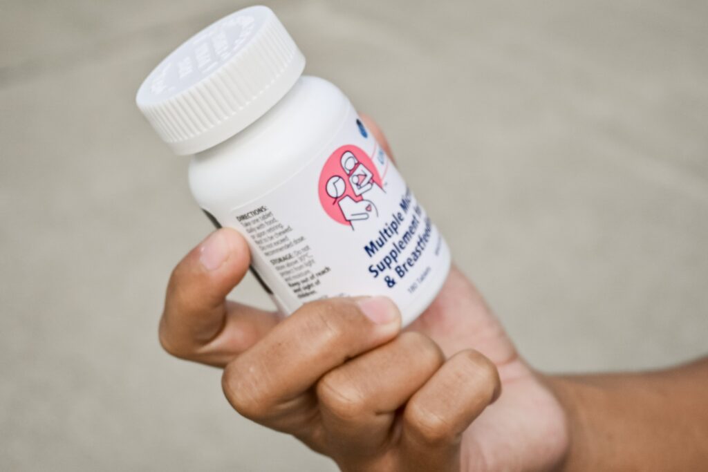 Hand holding breastfeeding mineral supplement bottle
