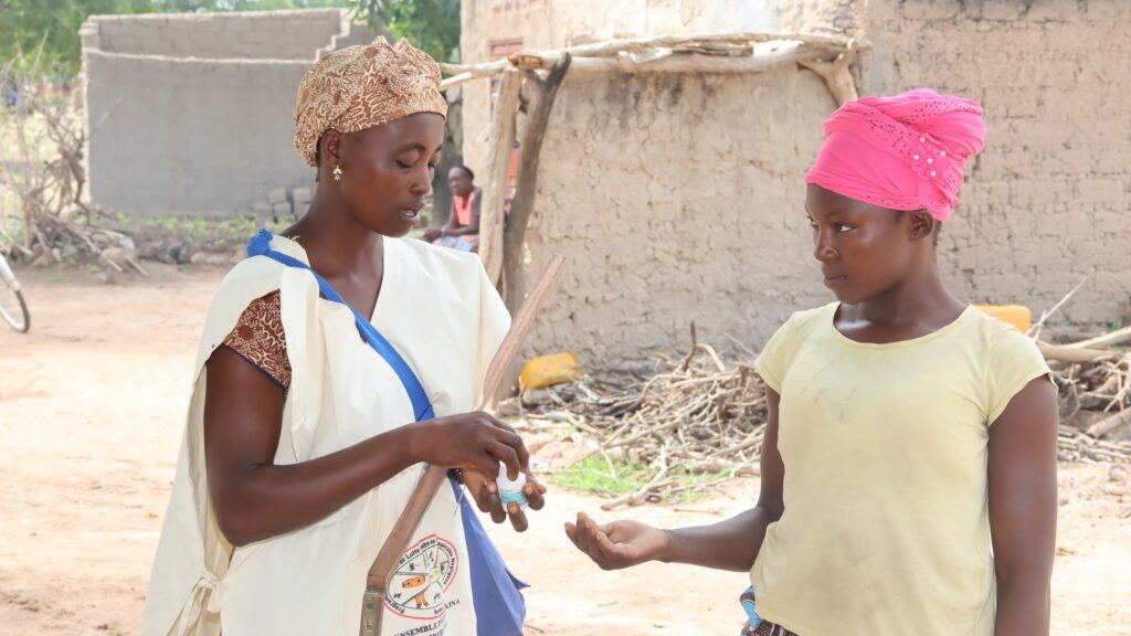 Health worker applying hand sanitizer outdoors