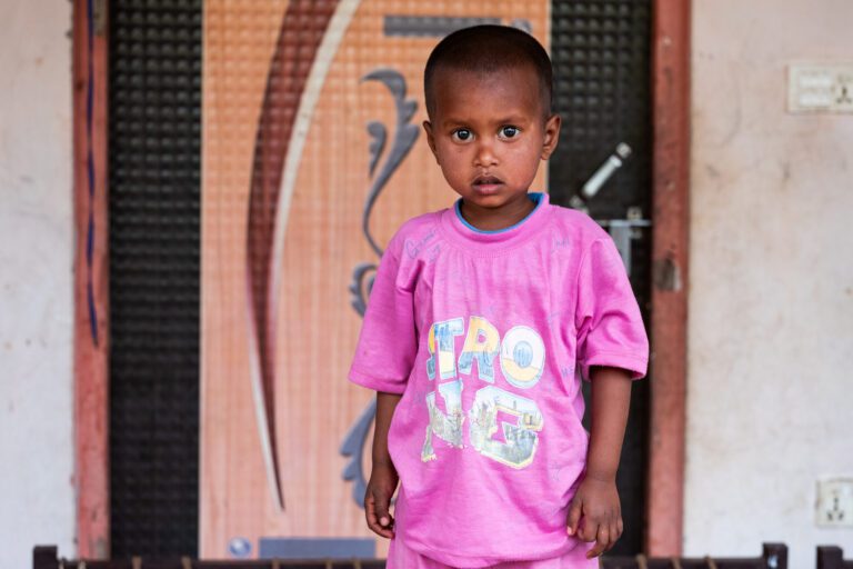 Young boy in pink Astro NG t-shirt indoors