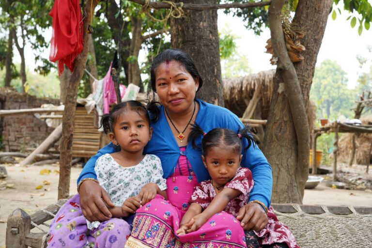 Mother sits with her two daughters after a visit to the local health care facility
