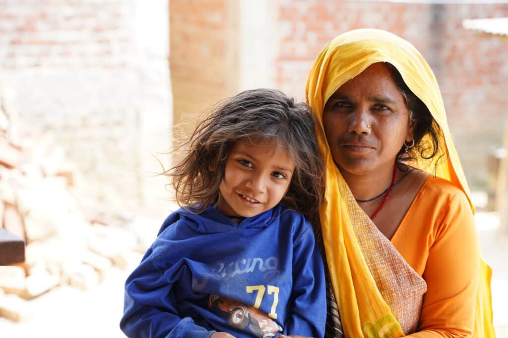 Mother in yellow headscarf with her around her young child