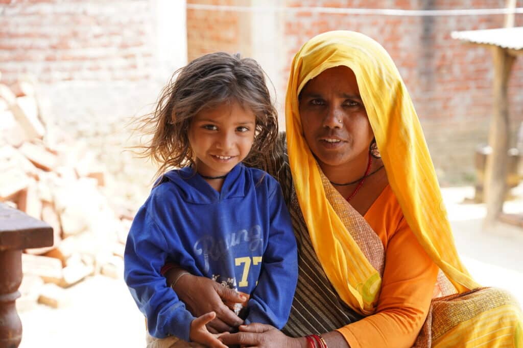 Woman with yellow head scarf embraces her son