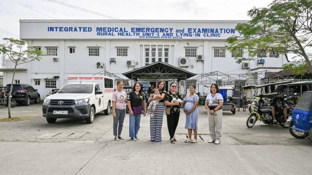 Suzette and her daughter, Misha, with other pregnant women and healthcare workers outside of a health center in Nueva Ecija.