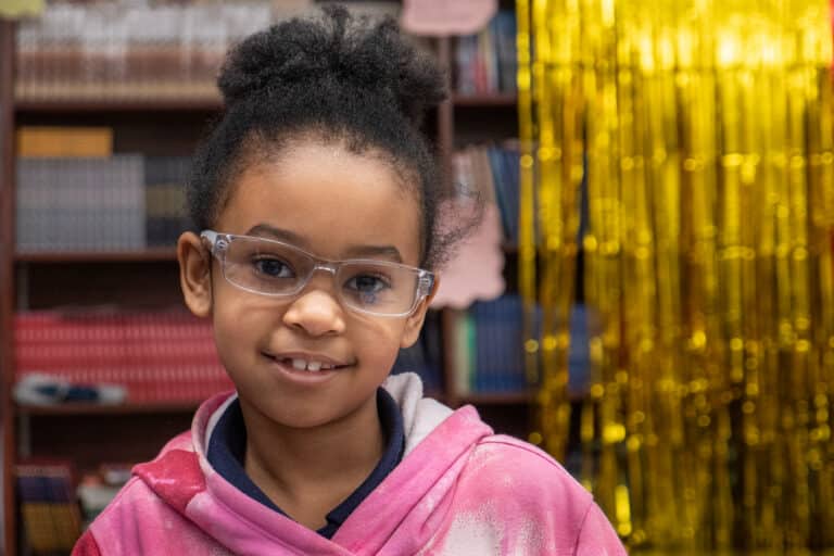 Young girl with glasses in pink sweatshirt