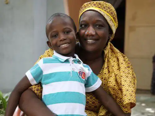 Mother holding smiling boy in striped shirt
