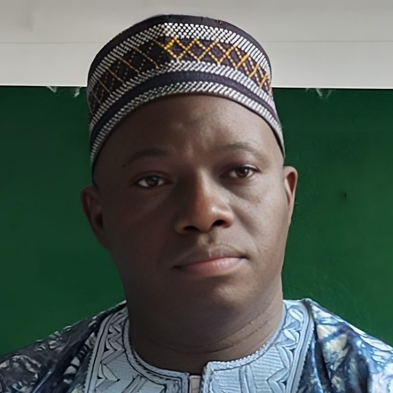 Man in traditional attire with patterned hat