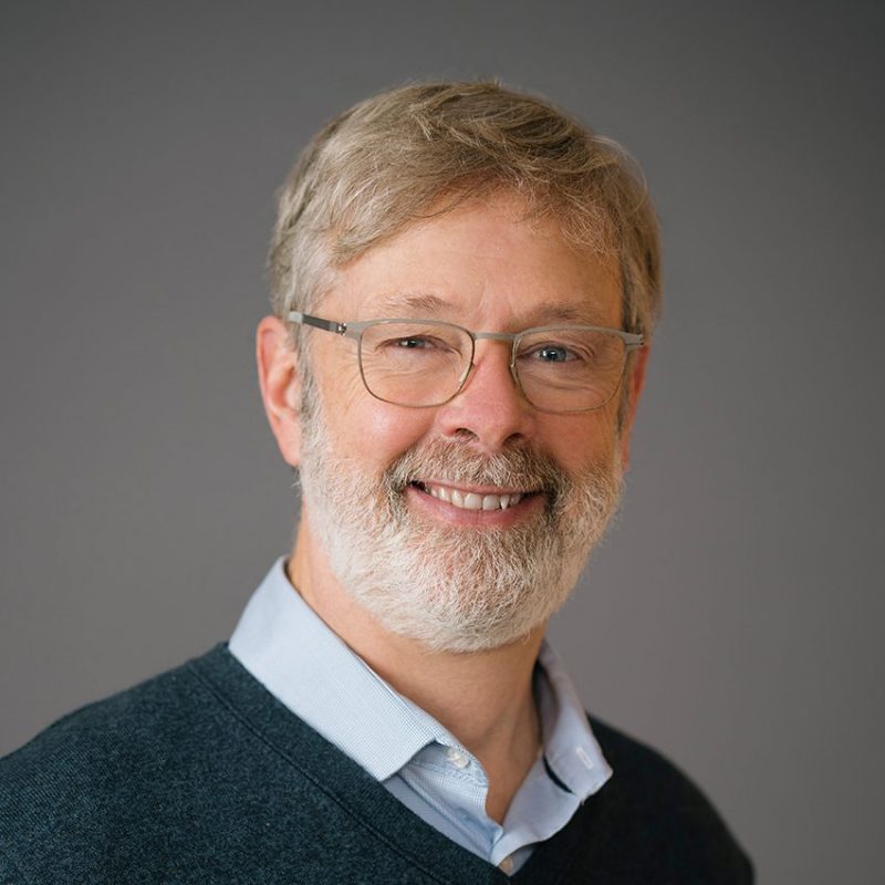 Headshot of smiling man wearing glasses