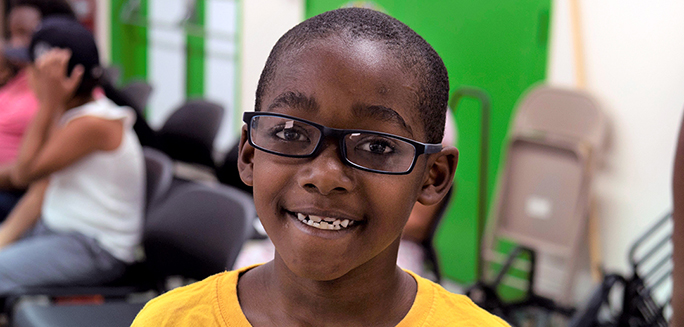 Eight-year-old Ezekiel wearing his new glasses