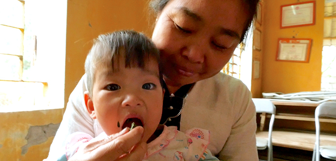 mother feeding her child in Vietnam